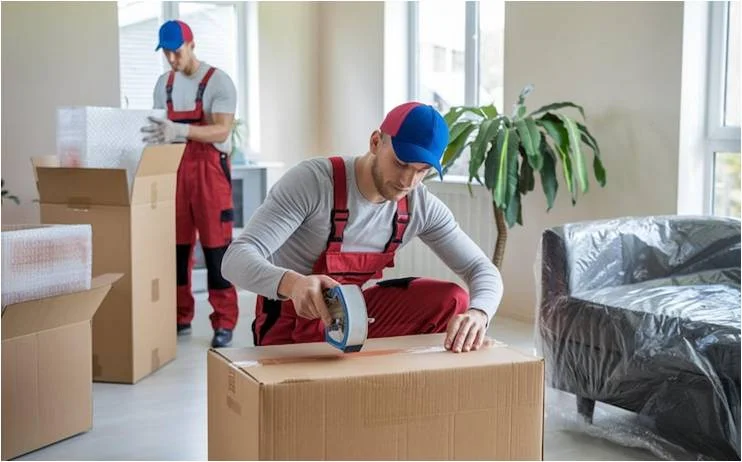 Professional packer sealing a cardboard box during household packing and unpacking services in Bangalore
